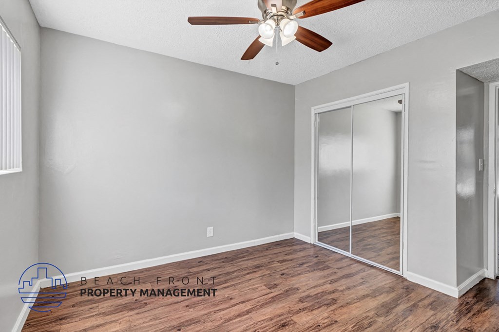 A room with a ceiling fan and a sliding door.